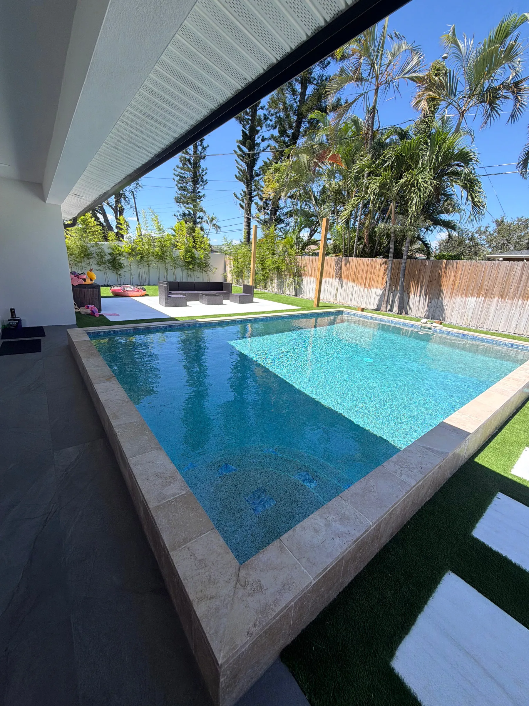 Pool and turf deck seen from under the lanai roof