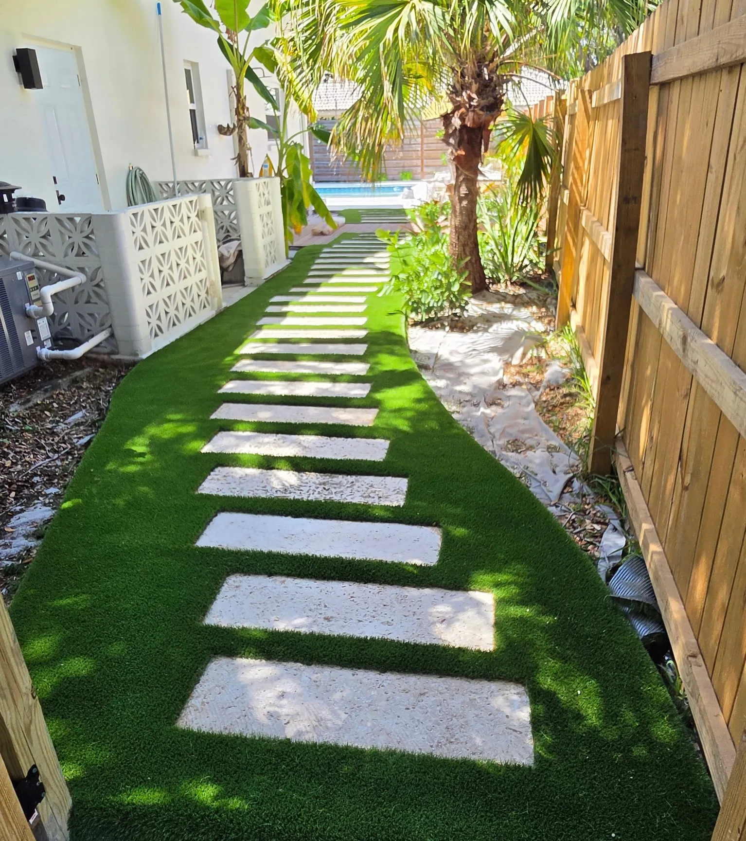 Artificial turf side yard with square concrete steppers